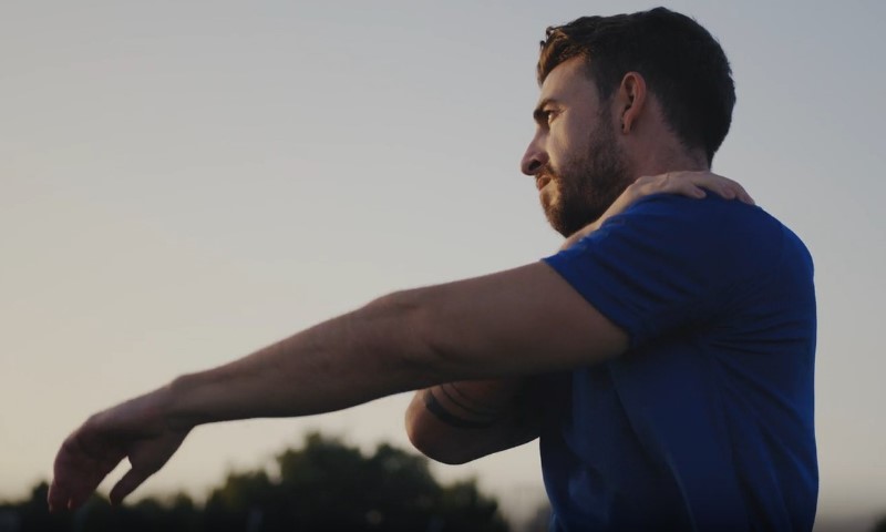 Čovek se isteže pre trening aktivnosti