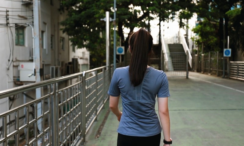 Devojka šeta gradom u majici i sa satom na ruci