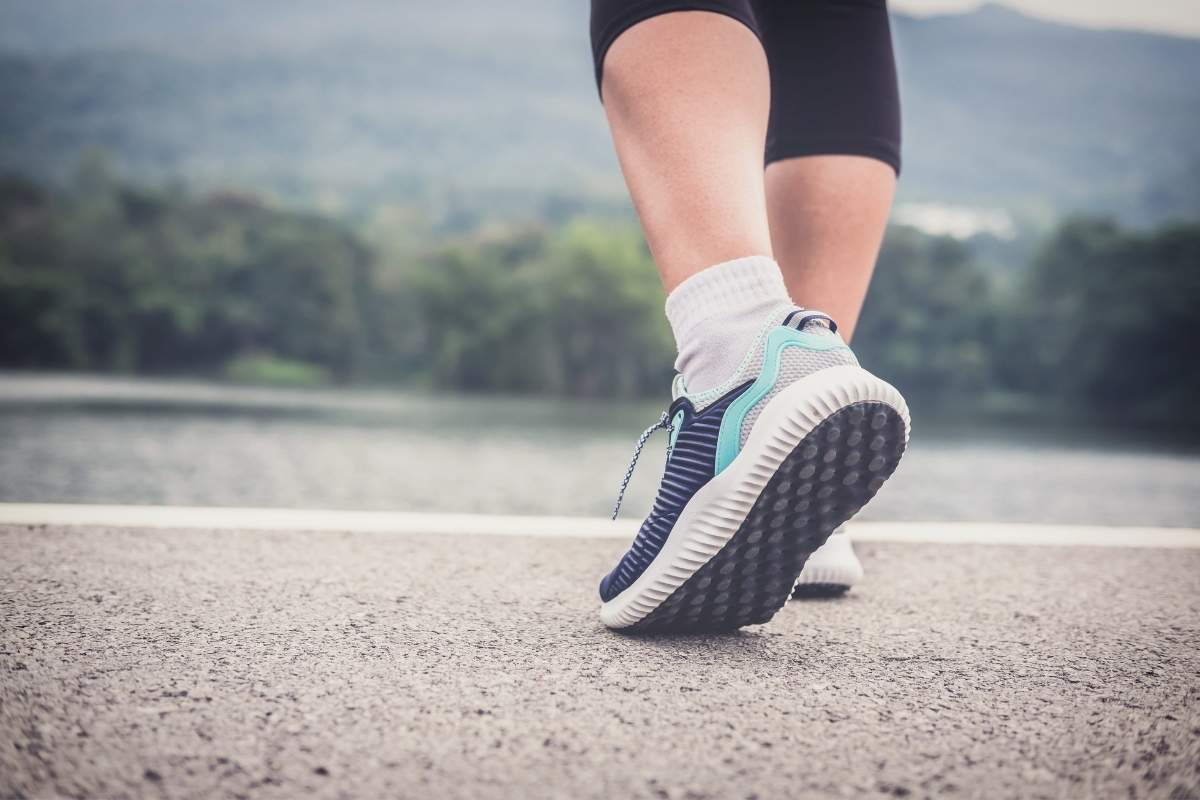 osoba u sportskim patikama šeta po ulici 