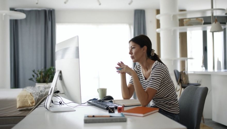 Žena prati online predavanje na računaru i uči nove veštine od kuće, koristeći obrazovne materijale tokom prekvalifikacije.